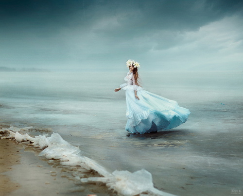 Обои Стройная девушка с венком из белых цветов на голове, в длинном платье бирюзового цвета, стоящая в прибрежной морской воде на фоне пасмурного неба и легкой, туманной дымки на линии горизонта, автор Светлана Беляева