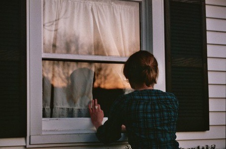 Парень с камерой в руках наблюдает за переодеванием девушки в окно