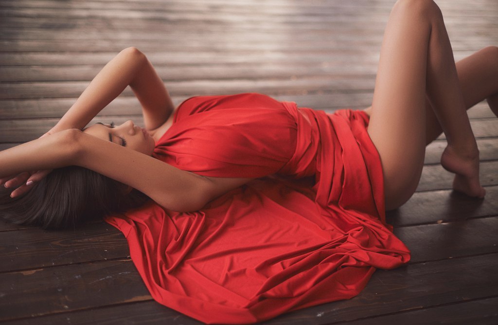 Женщина раздвинула ножки лежа на полу в красном платье