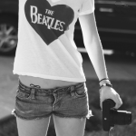 Аватар Девушка в футболке с надписью The Beatles с фотоаппаратом в руке