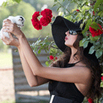 Аватар Девушка держит котенка, стоя возле цветов