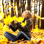 99px.ru аватар Девушка сидит на поляне в осеннем лесу и играет с листьями