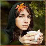 99px.ru аватар Девушка греет руки чашкой горячего чая, на волосах лежит красивый осенний лист клёна