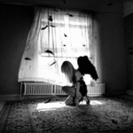 99px.ru аватар Девушка-ангел с черными крыльями сидит в комнате и на неё падают перья