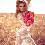 Аватар Девушка в белом прозрачном платье с букетом красных роз стоит в поле