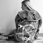 99px.ru аватар Девушка в свитере, на котором вышита пентаграмма, сидит у стены к нам спиной