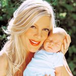 Аватар Счастливая мать Тори Спеллинг / Tori Spelling с младенцем на фоне зеленых кустов
