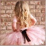 99px.ru аватар Девочка в розовом платье и длинными волосами стоит лицом к каменной стене