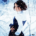 Аватар Обернувшаяся девушка стоит на фоне деревьев под падающим снегом