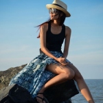 Аватар Девушка в шляпе сидит на камне на фоне неба и моря