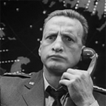 99px.ru аватар Мужчина в форме из фильма «Доктор Стрейнджлав, или Как я переста&;л боя&;ться и полюби&;л бо&;мбу» / «Dr. Strangelove or: How I Learned to Stop Worrying and Love the Bomb» сидит, держа телефонную трубку у уха, и что-то жует
