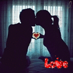99px.ru аватар Влюбленная пара в сумерках сидит напротив окна на кровати, прижимая пальцы рук, образуя сердце, с надписью Love / Любовь