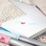 99px.ru аватар Две ручки лежащие рядом с открытым блокнотом с надписью (I. you / Я. тебя) с мерцающим сердечком на фоне в мелкий цветочек