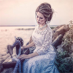 Аватар Девушка сидит на камнях и шьет на машинке, на фоне воды