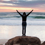 99px.ru аватар Девушка стоит с поднятыми руками на камне перед морем