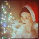 99px.ru аватар Девушка в шапке Санта Клауса с кошкой на плече, возле елки
