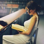 Аватар Девушка читает книгу, сидя в библиотеке