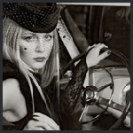Аватар Красивая девушка в шляпке с вуалью сидит за рулем автомобиля