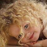99px.ru аватар Маленькая девочка с длинными кудрявыми волосами улыбается