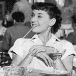 Аватар Одри Хепберн / Audrey Hepburn в фильме Римские каникулы / Roman Holiday сидит за столом с коктейльной трубочкой и улыбается