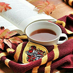 99px.ru аватар На столе рядом с чашкой чая лежат раскрытая книга, осенние листья и шарф Гриффиндора