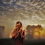 99px.ru аватар Девушка с длинными волосами стоит на фоне облачного неба