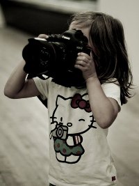Аватар вконтакте Девушка в футболке с Hello Kitty держит в руках фотоаппарат