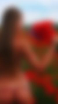Аватар вконтакте Обнаженная загорелая девушка с бусами на попе, стоит в поле, с букетом маков и васильков в руке
