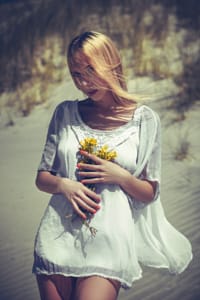 Аватар вконтакте Девушка в белом платье с желтыми цветами в руках стоит на фоне водоема, фотограф Ruslan Bolgov