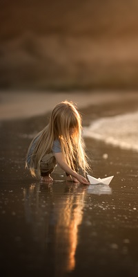 99px.ru аватар Маленькая девочка с длинными светлыми волосами, с бумажным корабликом сидит на берегу моря
