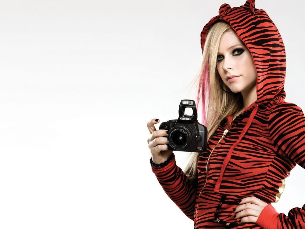 Обои для рабочего стола Аврил Лавин Avril Lavigne  в толстовке с ушками и с фотоаппаратом в руке