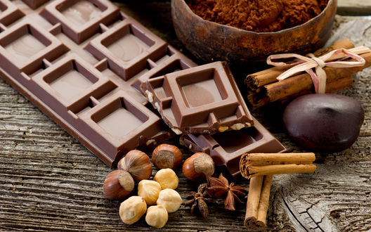 Обои Плитка шоколада, орехи, палочки корицы на деревянной поверхности