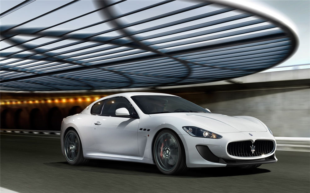Обои для рабочего стола Белая машина (Maserati GranTurismo MC Stradale) мчится по дороге