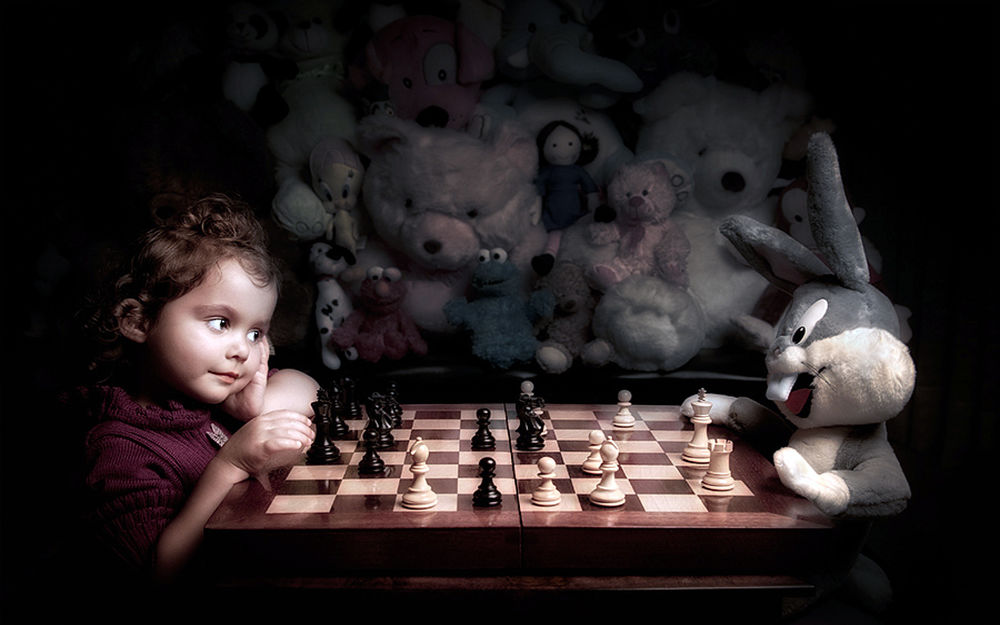 Обои для рабочего стола Девочка играет в шахматы с зайцем, за поединком наблюдают все игрушки