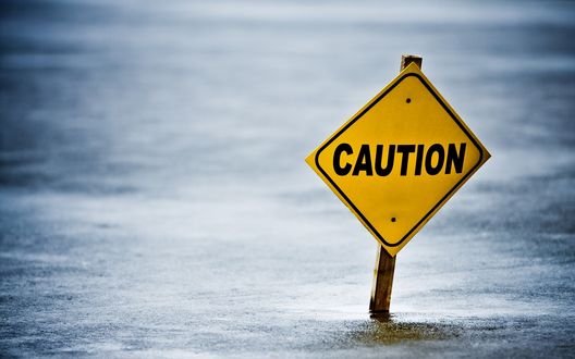 Обои на рабочий стол Знак Caution воткнут в лед
