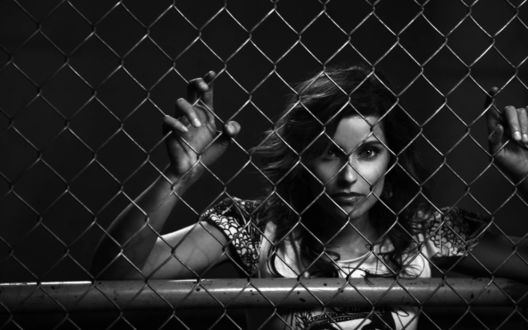 Обои на рабочий стол Певица Nelly Furtado / Нелли Фуртадо за решеткой