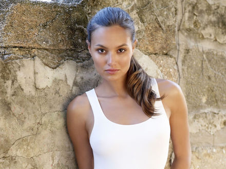 Обои на рабочий стол Шатенка Anne Marie Kortright  в белой майке у каменной стены