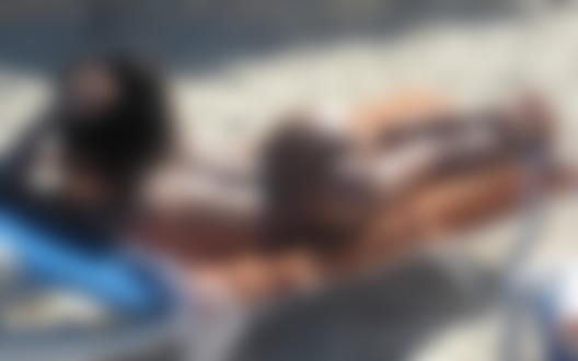 Обои для рабочего стола Девушка в стрингах загорает в на шезлонге топлес