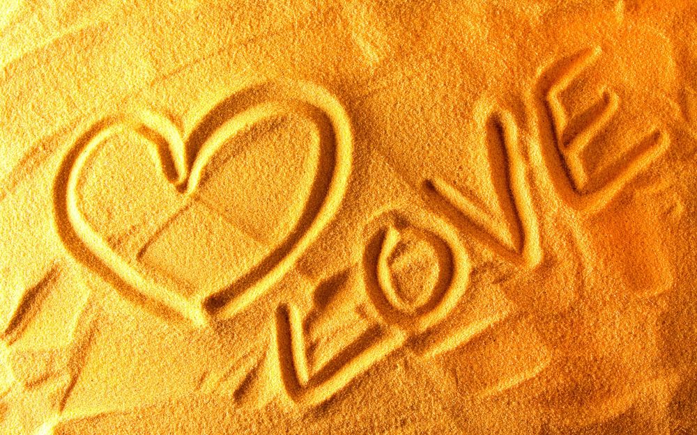 Обои для рабочего стола На песке нарисовано сердечко и надпись love