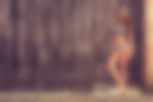 Обои на рабочий стол Девушка в черном бикини в белый горох стоит у деревянной колитки