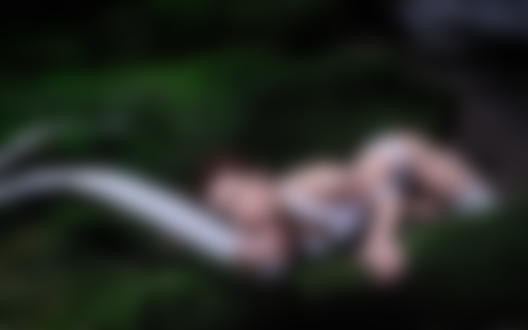 Обои для рабочего стола Девушка в белом белье и с белой лентой лежит на камне обросшим мхом