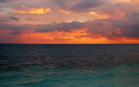 Обои на рабочий стол Спокойная гладь моря, над нею, розовеющее в первых лучах солнца, небо.