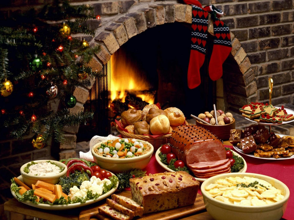 Обои для рабочего стола Рождественский стол, на нём картофельный и другие салаты, выпечка, в том числе и специально приготовленные рождественские звёзды, тут и красивая, сочная ветчина и традиционные пикули и, конечно, праздничное убранство завершает наряженная ёлочка и камин