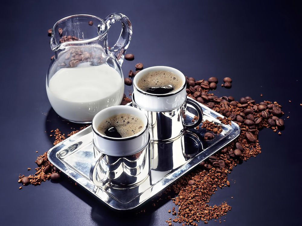 Обои для рабочего стола Две чашки кофе, и стеклянный кувшин с молоком на блестящем подносе, вокруг зерна кофе