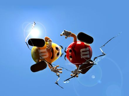 Обои на рабочий стол Красный и Желтый m&m's(ы) стоят на треснутом стекле и смотрят вниз