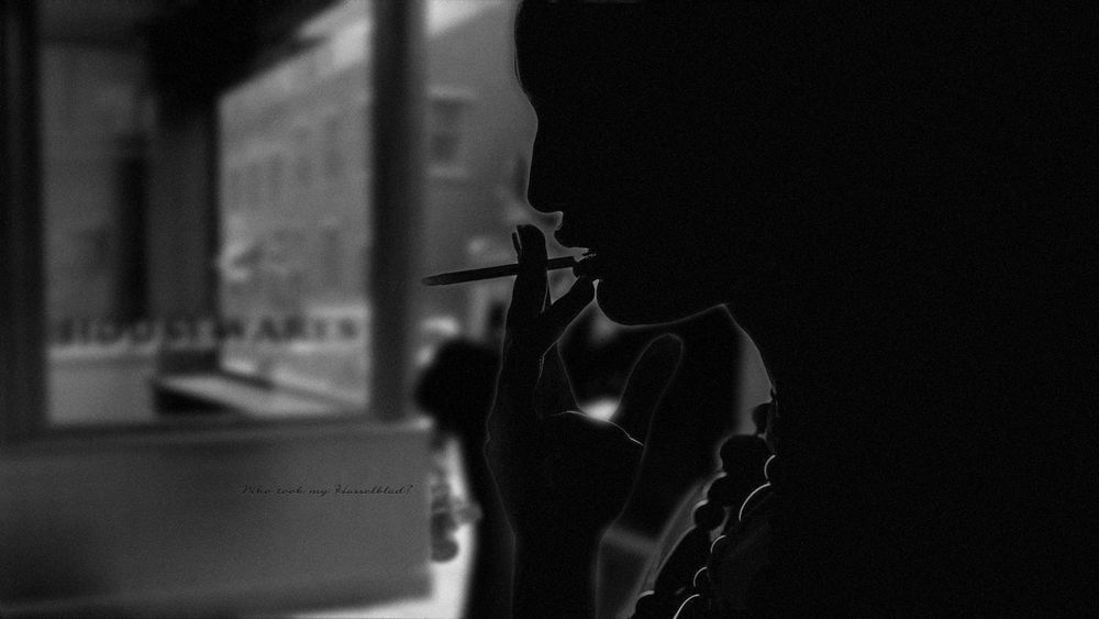 Обои для рабочего стола Девушка курит сигарету на фоне городской витрины (Who look my Hasselblad?)