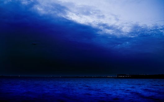 Обои на рабочий стол Штиль на море, вдали виднеются огоньки в домах