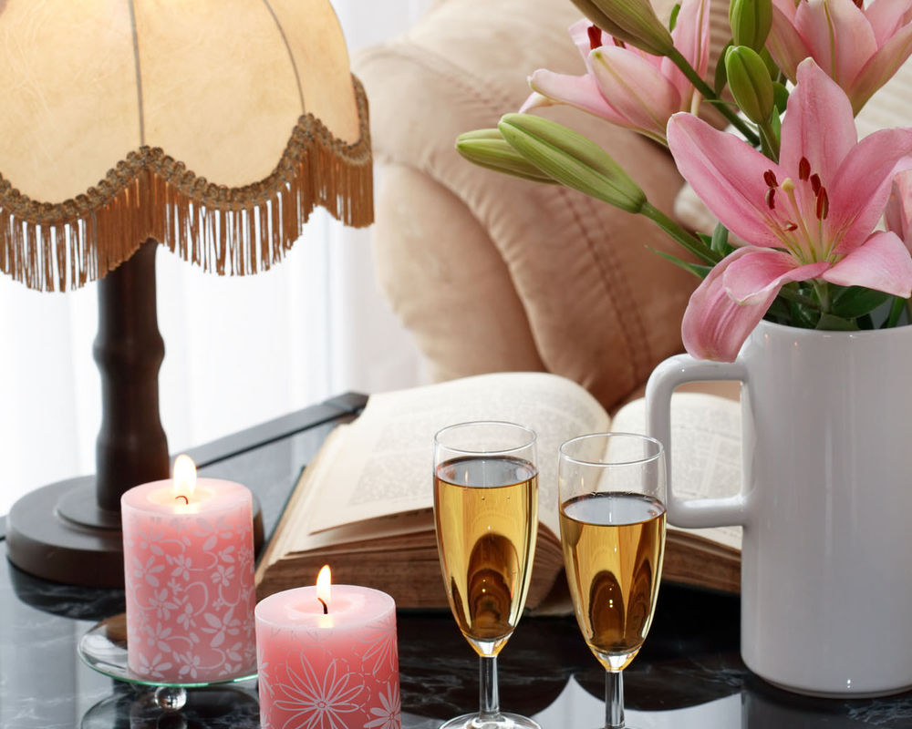 Обои для рабочего стола Ваза с лилиями на столе с книгой, свечами, шампанским и торшером