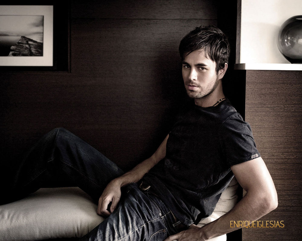 Обои для рабочего стола Певец Энрике Иглесиас / Enrique Iglesias на светлом диване у стены