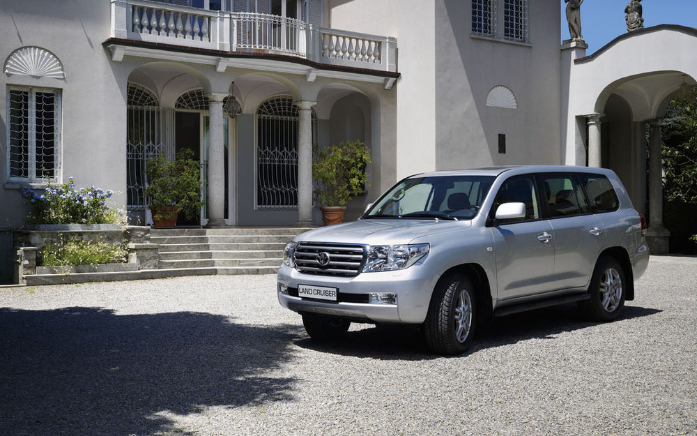 Обои для рабочего стола Автомобиль Toyota Land Cruiser 100 водворе шикарного дома